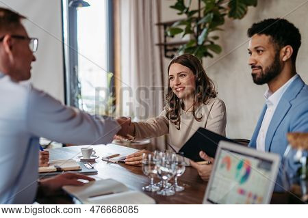 Close Up Of Businesmans Shaking Hands In Office.