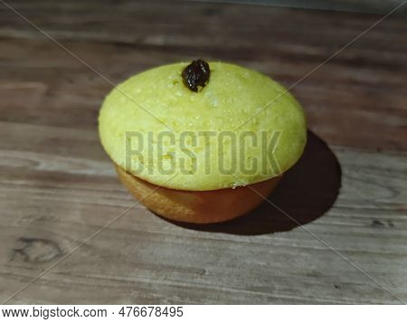 A Mud Cake With Raisin Topping Against A Background Of Wood Texture