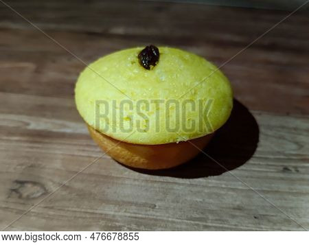 A Mud Cake With Raisin Topping Against A Background Of Wood Texture