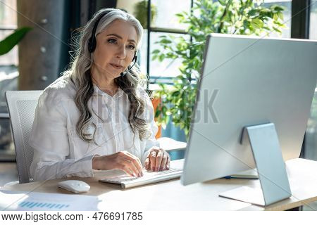 Good-looking Mature Business Woman At The Computrer Looking Busy