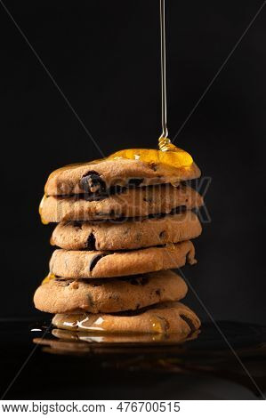 Honey Pours On Homemade Cookies With Pieces Of Chocolate On A Dark Background Close -up. A Compositi
