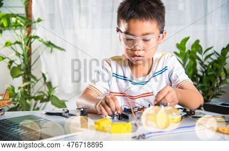 Asian Kid Boy Plugging Energy And Signal Cable To Sensor Chip With Arduino Robot Car, Little Child R