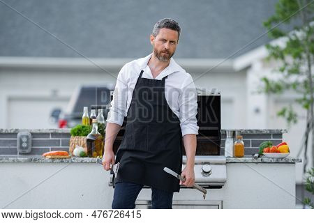 Cooking Meat On Barbecue In The Backyard Of The House. Handsome Man Preparing Barbecue. Barbecue Che