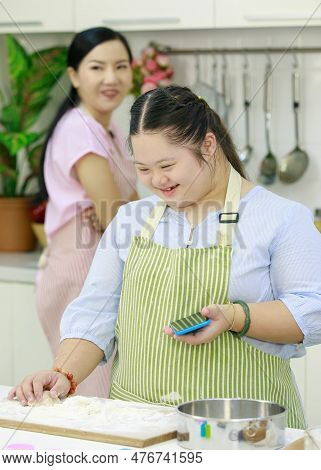 Asian Young Daughter Wears Apron Learning Baking Bakery Dessert Threshing Flour By Hands And Rolling