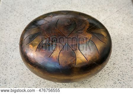 Steel Tongue Drum On Grey Table, Closeup. Percussion Musical Instrument