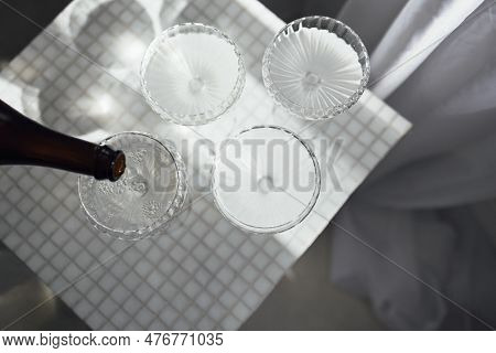Champagne Pourig Into Glasses On A Light Table Surface Reflecting Soft Sunshine Rayson. Sparkling Wi