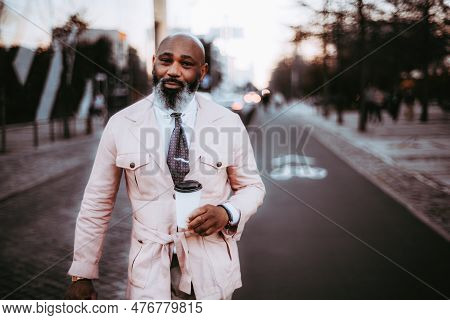 A Stylish Black Man With A Bald Head, Long Beard, And Hints Of White Hair, Dressed In A Pink Wrap Ja