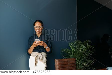 Young Female Entrepreneur In Thought Sitting On The Floor In The Kitchen With A Laptop On Her Legs