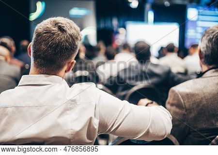 Speaker Giving A Talk In Conference Hall At Business Event. Rear View Of Unrecognizable People In Au