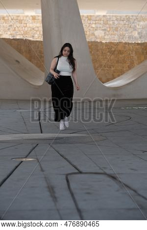 Young Attractive Woman Wearing Casual And Holding A Handbag Clothing Walking Outdoors In The City.