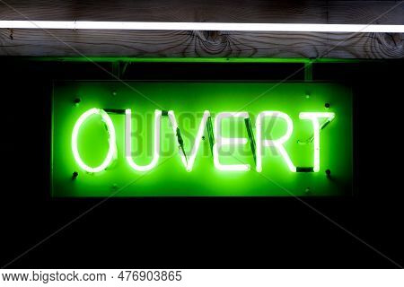 Green Neon Light Shaped Into The French Word Meaning 