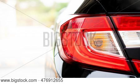 Close Up Tail Light Of Black Car. In The Pakring Lot. With Abstract And Blurred Of Background With S