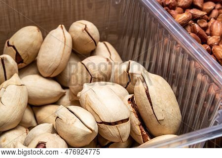 Inshell Pecans In Plastic Conteiner. Selective Focus