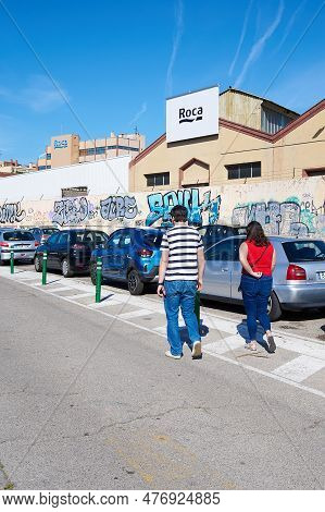 Gava - May 27, 2023: Couple Passing By The Back Of The Roca Factory.