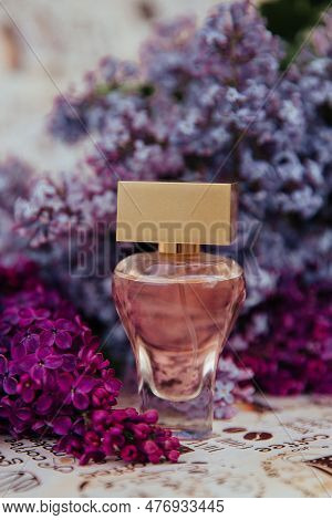 A Bottle Of Perfume Among The Flowers