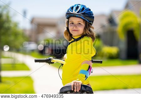 Little Kid Boy Ride A Bicycle In The Park. Kid Cycling On Bicycle. Happy Smiling Child In Helmet Rid