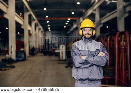 A Confident Heavy Industry Worker Standing In Facility And Smiling At The Camera.