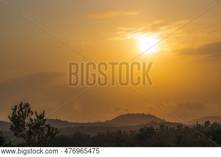 A Tranquil Scene Of Beauty In Nature, With A Dramatic Orange Sky Reflecting Off The Foggy Mountain A