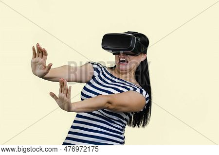 Young Woman In Vr Headset Is Stratched Her Hands In Fear. Experiencing Scary Virtual Reality. Isolat