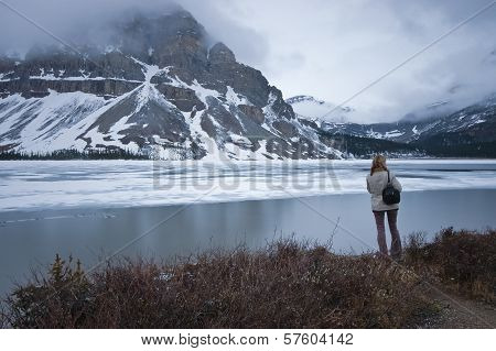 A Tourist Stands Near Snow Mountain