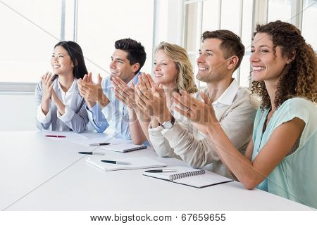 Casual business team clapping at presentation in the office