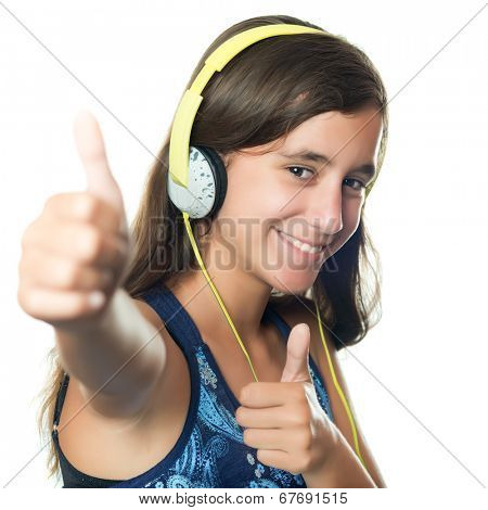 Beautiful hispanic teenager listening to music on her headphones while doing a thumbs up sign isolated on white