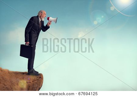 Senior Businessman Yelling Through A Loudhailer