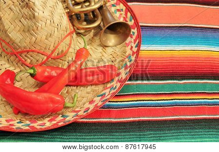 fiesta mexican poncho rug in bright colors with sombrero background with copy space