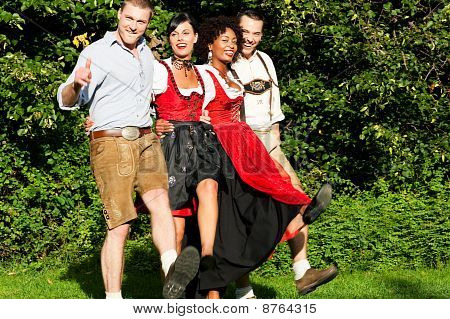 Gruppe af fire venner i bayerske Tracht dans