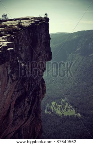 Hiker look down from Taft Point in Yosemite.