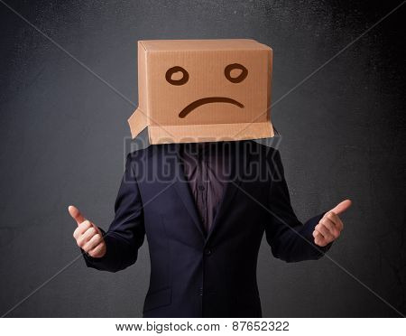 Young man standing with a brown cardboard box on his head with sad face