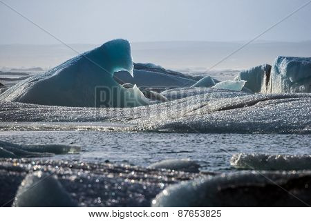 Glacier ice lagoon in Jokullsarlon, Iceland. The glacier breaks up into ice blocks in the lagoon before flowing out to sea as icebergs.