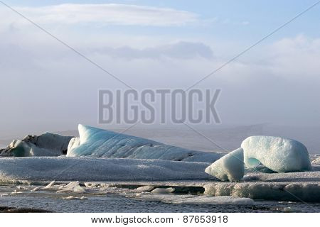 Glacier ice lagoon in Jokullsarlon, Iceland. The glacier breaks up into ice blocks in the lagoon before flowing out to sea as icebergs.