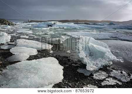 Glacier ice lagoon in Jokullsarlon, Iceland. The glacier breaks up into ice blocks in the lagoon before flowing out to sea as icebergs.