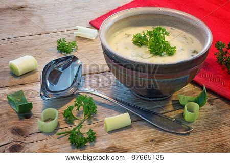 Cream Sauce In A  Bowl With  Leek And Herbs On  Rustic Wood