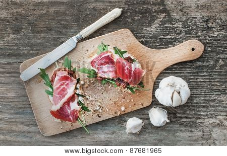 Brushetta Set With Smoked Meat, Arugula, Garlic And Dried Tomato
