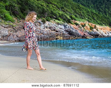 A Young Blond Haired Woman Walking Along The Beach