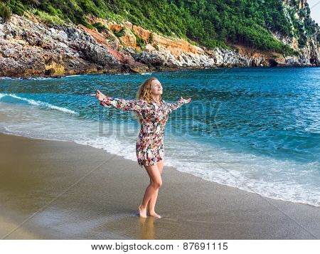 A Young Blond Haired Woman Walking Along The Beach