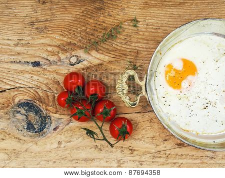 Breakfast Set: Fried Egg And Cherrytomato On A Wooden Desk