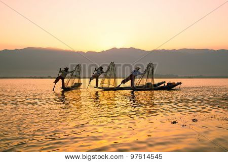 Three fishermen catches fish for food in sunrise in Inle Lake, Myanmar