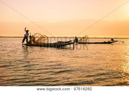 Three fishermen catches fish for food in sunrise in Inle Lake, Myanmar