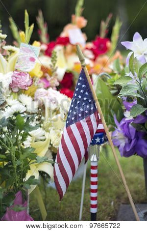 flag and flowers on grave