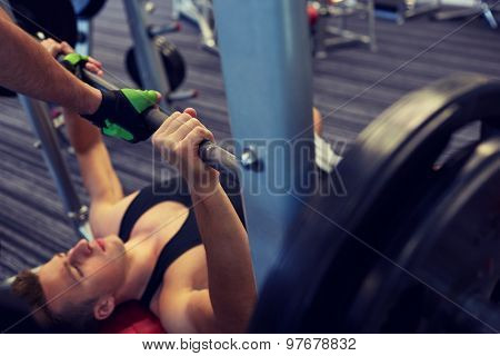 sport, fitness, teamwork, weightlifting and people concept - young man and personal trainer with barbell flexing muscles in gym
