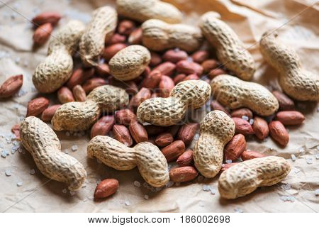 Salted peanuts are peeled and inshelled on a paper bag. Studio macro shoot