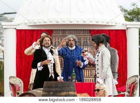 FUNCHAL MADEIRA PORTUGAL - SEPTEMBER 4 2016: Men in historical fashion dress raise toasts durnig historical and ethnographic parade of Madeira Wine Festival in Funchal. Madeira Portugal
