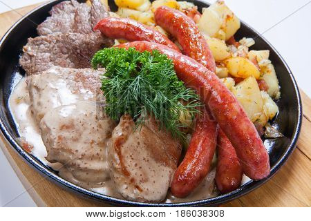 Grilled Sausages With Potatoes, And Roasted Meat On A Grill Pan