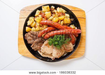 Grilled Sausages With Potatoes, And Roasted Meat On A Grill Pan