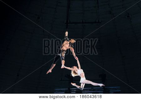 Stunt aerialists men and women in the circus. Love, danger, and romance concept.