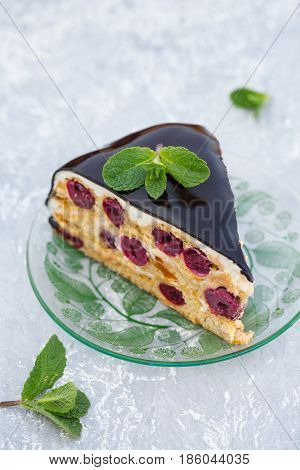 Cake with cherry, cream and chocolate icing