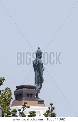 The old buddha statue stand on lotus in Thailand.